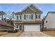 Two-story home with stone accents, a two-car garage, and a well-kept lawn at 9032 Jim Purcell Dr, Covington, GA 30014