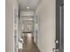Inviting hallway featuring hardwood floors, neutral paint, and views of the living area at 9032 Jim Purcell Dr, Covington, GA 30014