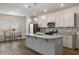 Modern kitchen with stainless steel appliances, gray cabinets, granite countertops, and a large island at 9032 Jim Purcell Dr, Covington, GA 30014
