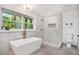 Modern bathroom featuring a soaking tub with gold fixtures and a separate shower with white marble style tile at 2685 Glenvalley Dr, Decatur, GA 30032