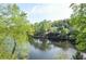 Scenic lake view surrounded by lush greenery and mature trees with a neighboring home in the distance at 4730 W Forest Peak, Marietta, GA 30066