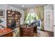 Elegant office space featuring a large desk, hardwood floors, built-in bookshelves, and a window with natural light at 4730 W Forest Peak, Marietta, GA 30066