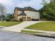 Side view of home with a two-car garage, long driveway, and lush green lawn on a cloudy day at 533 Mount Gerizim Se Rd, Mableton, GA 30126