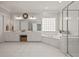 Bright white bathroom features a double vanity, glass-block window, soaking tub, and glass-enclosed shower at 5604 Mccullers Ln, Loganville, GA 30052