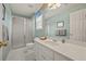 Bathroom with mint walls, shower, toilet and double sink with white cabinetry, and decor at 5604 Mccullers Ln, Loganville, GA 30052