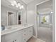 Light and airy bathroom with double sinks, white cabinetry and view to another bedroom at 5604 Mccullers Ln, Loganville, GA 30052