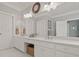 Bathroom showcasing double sinks, white cabinets and ample counter space with decor and a clock above the vanity at 5604 Mccullers Ln, Loganville, GA 30052