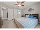 This bedroom has a windmill accent, a ceiling fan, and includes a hallway leading to a bathroom at 5604 Mccullers Ln, Loganville, GA 30052
