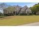 Inviting brick home featuring a manicured front lawn and mature landscaping, enhancing its curb appeal at 5604 Mccullers Ln, Loganville, GA 30052