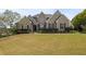 Inviting brick home featuring a manicured front lawn and mature landscaping, enhancing its curb appeal at 5604 Mccullers Ln, Loganville, GA 30052