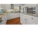 Bright kitchen features white cabinets, stainless steel appliances, granite countertops and hardwood floors at 5604 Mccullers Ln, Loganville, GA 30052