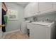 Laundry room with washer, dryer, utility sink and storage cabinets at 5604 Mccullers Ln, Loganville, GA 30052