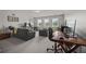This room includes three windows and furnishings such as an office, love seat, chair, desk, and television at 5604 Mccullers Ln, Loganville, GA 30052