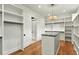 Spacious closet with custom shelves and a center island, illuminated by a stylish pendant light at 820 Moores Mill Nw Rd, Atlanta, GA 30327