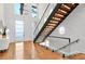 Bright foyer features wood floors, stairs with glass railings, and a modern light fixture at 820 Moores Mill Nw Rd, Atlanta, GA 30327