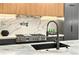 Modern kitchen features a marble backsplash, professional-grade range, and sleek black fixtures at 820 Moores Mill Nw Rd, Atlanta, GA 30327