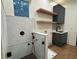 Modern laundry room with white marble tiled shower, gray cabinets, and floating shelves at 820 Moores Mill Nw Rd, Atlanta, GA 30327