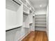 Spacious walk-in closet with custom shelving, hanging rods, and wood floors at 820 Moores Mill Nw Rd, Atlanta, GA 30327