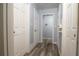 Long hallway with wood-look floors, neutral paint, and multiple doors at 98 Almon Church Rd, Covington, GA 30014