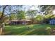 Spacious backyard with lush green grass, mature trees, a screened-in porch, and storage shed at 2685 Buena Vista Ave, Doraville, GA 30340