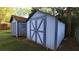Two weathered storage sheds with contrasting blue trim sit in a well maintained yard at 2685 Buena Vista Ave, Doraville, GA 30340