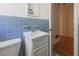 Bathroom with blue tiled walls, white sink, and wooden floors in adjacent hallway at 2685 Buena Vista Ave, Doraville, GA 30340