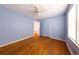 Bedroom with wood floors, blue walls, ceiling fan, and a window with natural light at 2685 Buena Vista Ave, Doraville, GA 30340