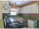 Galley-style kitchen with white cabinets, black appliances, and green countertops at 2685 Buena Vista Ave, Doraville, GA 30340