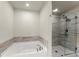 Bright bathroom featuring a soaking tub and glass enclosed shower with gray and white marbled tile surround at 350 Hayden Cir, Woodstock, GA 30189
