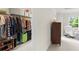 Walk-in closet with wire shelving, hanging clothes, and shoe rack; next to sitting area with chair and window at 350 Hayden Cir, Woodstock, GA 30189