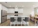 Bright kitchen features white cabinets, stainless steel appliances, a central island with bar seating, and hardwood floors at 350 Hayden Cir, Woodstock, GA 30189