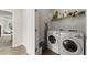 Laundry room featuring front-load washer and dryer with wire shelving, and ironing board at 350 Hayden Cir, Woodstock, GA 30189
