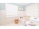 The elegant bathroom features a cozy tub, wood-paneled walls, complemented by classic white tile flooring and a charming basket at 914 Denmeade Sw Walk, Marietta, GA 30064