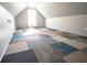 Bright attic with a neutral palette and patchwork carpet tiles under a window and clean walls at 191 Fairview Oak Trl, Dallas, GA 30157