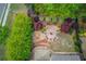 Aerial shot of a landscaped backyard showcasing a stone patio, fire pit, and lush greenery at 2631 Moon Chase Lane, Buford, GA 30519