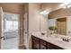 Double sink bathroom vanity with large mirrors and views of a bedroom with chandelier at 2631 Moon Chase Lane, Buford, GA 30519