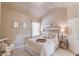 This cozy bedroom has a plush bed, soft lighting, and vaulted ceiling at 2631 Moon Chase Lane, Buford, GA 30519