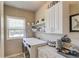 Functional laundry room featuring modern washer/dryer, shelving, and ample counter space at 2631 Moon Chase Lane, Buford, GA 30519