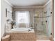 Serene bathroom features a soaking tub, glass shower, and neutral color palette, creating a relaxing space at 2631 Moon Chase Lane, Buford, GA 30519
