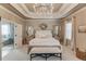 Elegant main bedroom showcases a tray ceiling, chandelier, and stylish decor, offering a peaceful oasis at 2631 Moon Chase Lane, Buford, GA 30519