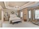 Serene main bedroom features a tray ceiling, chandelier, and neutral decor, creating a relaxing retreat at 2631 Moon Chase Lane, Buford, GA 30519