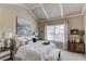 Vaulted ceiling primary bedroom boasts a king bed, bench, and large picture window at 2631 Moon Chase Lane, Buford, GA 30519