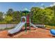 Community playground with colorful slide and play structure on a mulch surface and green surroundings at 2631 Moon Chase Lane, Buford, GA 30519