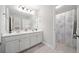 Bright bathroom featuring dual sinks, vanity, large mirror, and a shower-tub combo at 2890 Canter Meadow Dr, Cumming, GA 30040