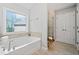 Bathroom with soaking tub, tiled shower, and ample natural light through a large window at 2890 Canter Meadow Dr, Cumming, GA 30040