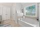 Bright bathroom featuring a soaking tub and a window with natural light at 2890 Canter Meadow Dr, Cumming, GA 30040