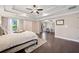 Bright main bedroom features a tray ceiling, hardwood floors, and large windows at 2890 Canter Meadow Dr, Cumming, GA 30040