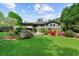 Beautiful backyard featuring a lush green lawn, patio area with umbrella, and colorful landscaping at 2920 Dara Dr, Marietta, GA 30066