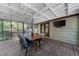 Inviting screened porch with wood flooring, ceiling fan, outdoor TV, and dining table, perfect for outdoor entertaining at 2920 Dara Dr, Marietta, GA 30066