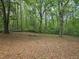 Large backyard with mature trees and a fenced in area at 14 Highland Dr, Carrollton, GA 30116